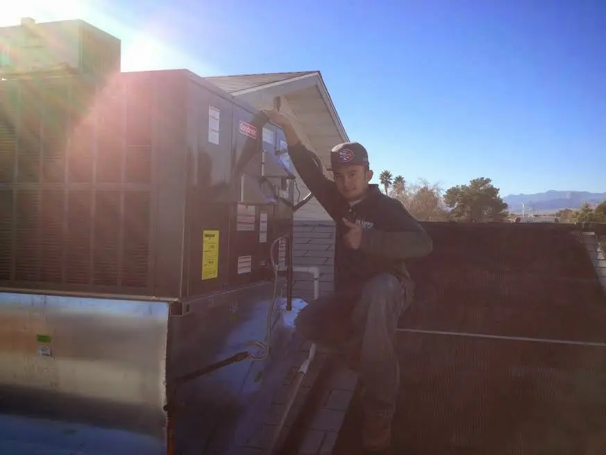 HVAC technician performing Air Duct Cleaning on a rooftop unit in Moultrie